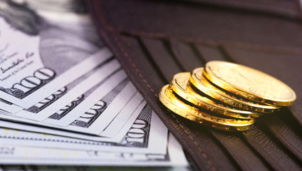 closeup stack metal coins, hundred dollars banknotes with wallet