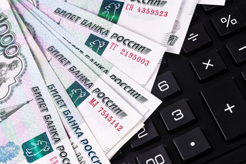 finance concept in closeup calculator and Russian money, rubles banknotes background