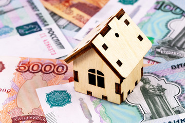finance concept in wooden house symbol on the Russian money, rubles banknotes background