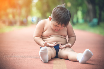 Fat chubby boy tired of exercise. Fat children need parent attention on  weight loss for healthy life.