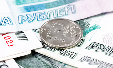 one russian ruble metal coin and 1000 thousand rubles banknotes closeup