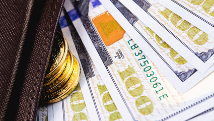 stack golden metal coins and dollars banknotes in wallet closeup
