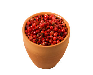 Red pepper in a bowl on isolate. View from above. Seasoning with peas of red pepper isolated on a white background. Close-up.