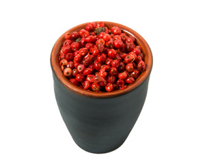Red pepper in a bowl on isolate. View from above. Seasoning with peas of red pepper isolated on a white background. Close-up.