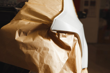 Garage painting car service. vehicle cover with protective paper before painting.