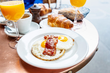 classical english breakfast with egg and croissants