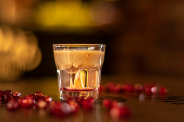 baileys shot with grenadine seeds on wooden table