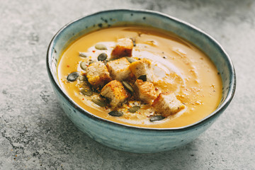 Homemade pumpkin soup in a bowl with croutons, close-up.