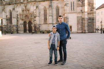 Two brothers walk in the city together. Happy family outside