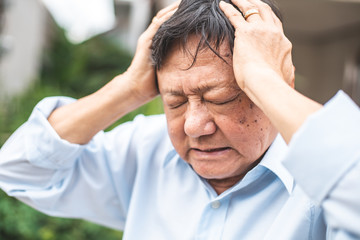 Portrait of an elderly man with headache.senior man covering his face with his hands.vintage tone..