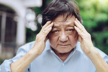 Portrait of an elderly man with headache.senior man covering his face with his hands.vintage tone..