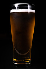 Glass of beer on black background