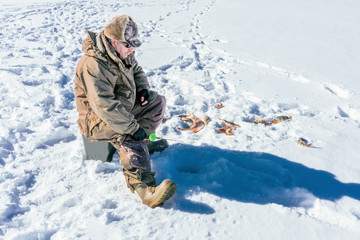 Fototapeta na wymiar winter fishing Fisherman enjoying a day on the ice