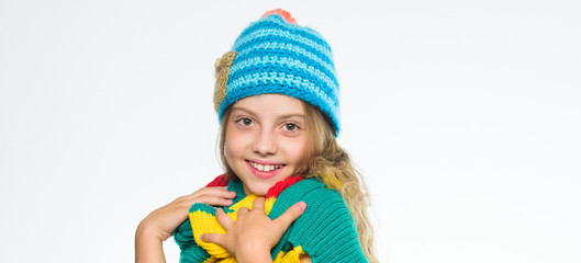Fototapeta na wymiar Which fabrics will keep you warmest this winter. Girl long hair happy face white background. Kid wear warm soft knitted blue hat and long scarf. Warm woolen accessories. Hat and scarf keep warm
