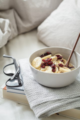 Breakfast and reading in bed. Oatmeal with banana and cranberries in bed.