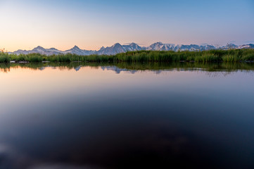 Fototapeta na wymiar Eiger, Mönch und Jungfrau spiegeln sich in kleinem Tümpel im Morgenrot