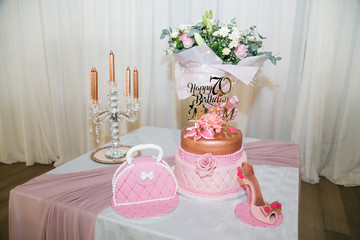 happy 70th birthday mom in rose gold on birthday cake with shoe and handbag fresh flowers
