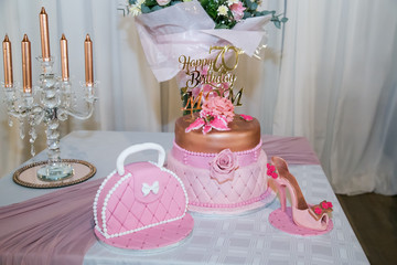 happy 70th birthday mom in rose gold on birthday cake with shoe and handbag fresh flowers