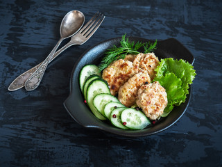 A plate with Breakfast consisting of Turkey and vegetable cutlets stands on a dark background