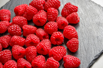 Himbeeren auf schwarzer Schieferplatte