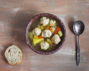 Hot vegetable soup with Turkey meat meatballs in a deep dish, top view