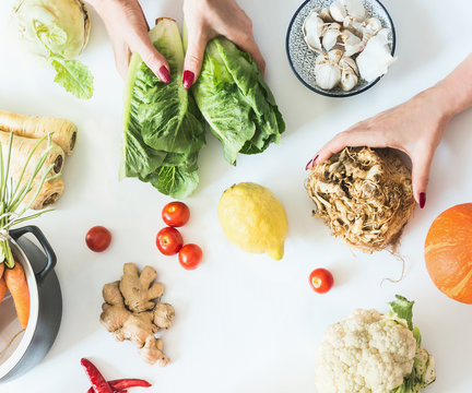 Female Girls Hands Holding Various Low Carb Vegetables On White Background With Pot, Top View. Flat Lay. Tasty Diet Cooking. Healthy Food Lifestyle. Clean Eating. Low Calorie Vegetarian Food.