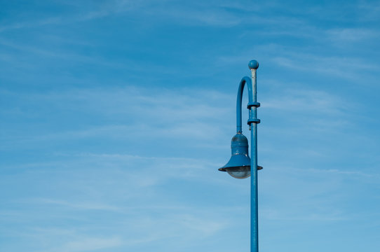Closep of blue metallic street lapm on blu sky background