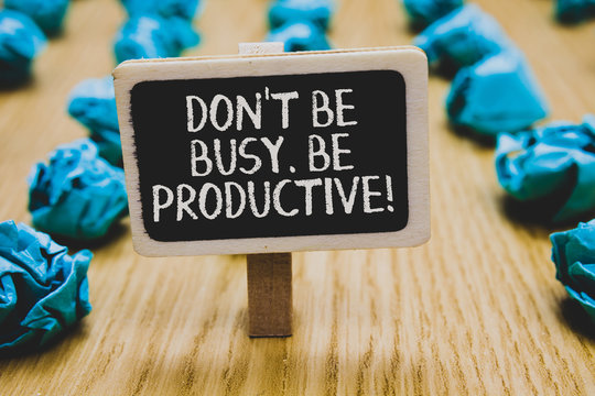 Handwriting text writing Don t not Be Busy. Be Productive. Concept meaning Work efficiently Organize your schedule time Stand blackboard with white words behind blurry blue paper lobs woody floor