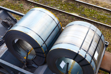 Rolled steel coil on on a freight train fixed by a chain. Import/export, logistics of the heavy...