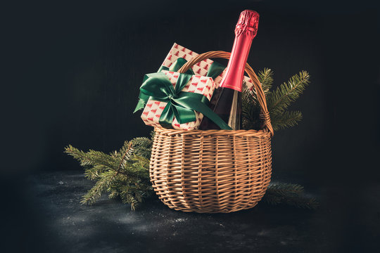 Christmas gift hamper with champagne and gift on black. Space for your greetings. greeting card