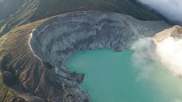 Aerial drone view of beautiful Ijen volcano with acid lake and sulfur gas going from crater, Indonesia