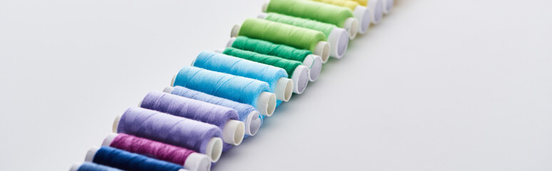 selective focus of bright and colorful threads on white background