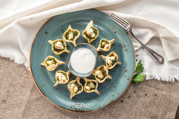 Crispy open pie borak with spinach and cheese on blue plate on tablecloth
