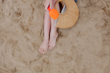 Girl oil spray tanning her legs protection from the sun's uv rays putting sunscreen lotion sunblock Unrecognizable girl with her beach essentials for a summer holiday.