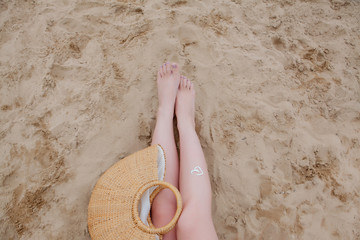 Girl oil spray tanning her legs protection from the sun's uv rays putting sunscreen lotion sunblock...
