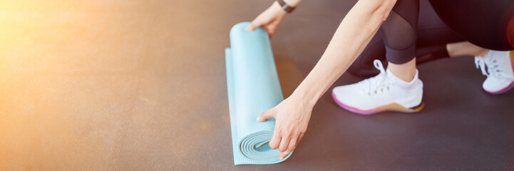 Frau mit Yogamatte macht Yoga Training zu Hause