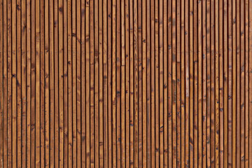 Background of the boards facing the wall. The texture of the wooden surface of the boards. Smooth dark brown planks with knots.