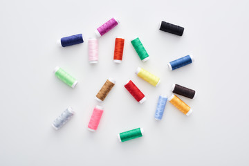 top view of bright and colorful threads on white background