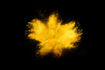 Gelbe Pulverexplosion auf schwarzem Hintergrund.