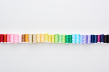 top view of bright and colorful threads on white background