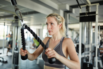Fototapeta na wymiar Junge Frau trainiert Trizeps Muskel mit dem Seil