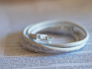 An Ethernet network cable coiled on a printed sheer of paper.