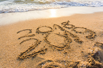 Number 2019 sign on sand beach wave sunset light