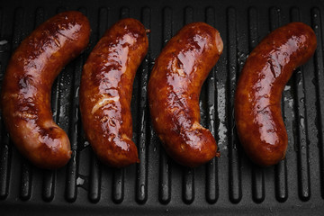 grilled sausages on hot grill pan. top view