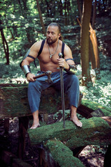 Muscular and strong man with ax and sword