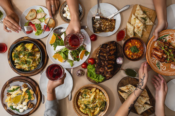 wide and tasty table covered with delicious Ukrainian cuisine on which sits a large family or...