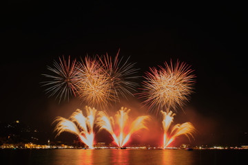 Firework show on Lake Garda, celebration (Sant Ercolano). In the city of Toscolano Maderno Italy. Aerial view.