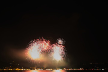 Firework show on Lake Garda, celebration (Sant Ercolano). In the city of Toscolano Maderno Italy. Aerial view.