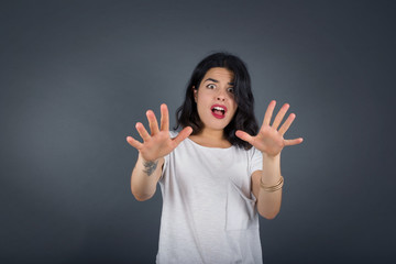 Dissatisfied female model frowns face, has disgusting expression, shows tongue, expresses non...