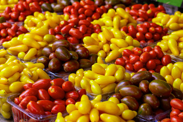 colorful red brown and yellow plumps open air market counter fruit background  